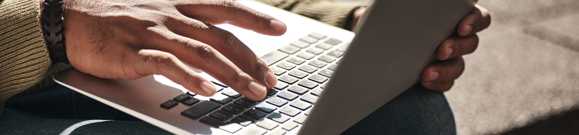 Close-up of a person typing on a laptop