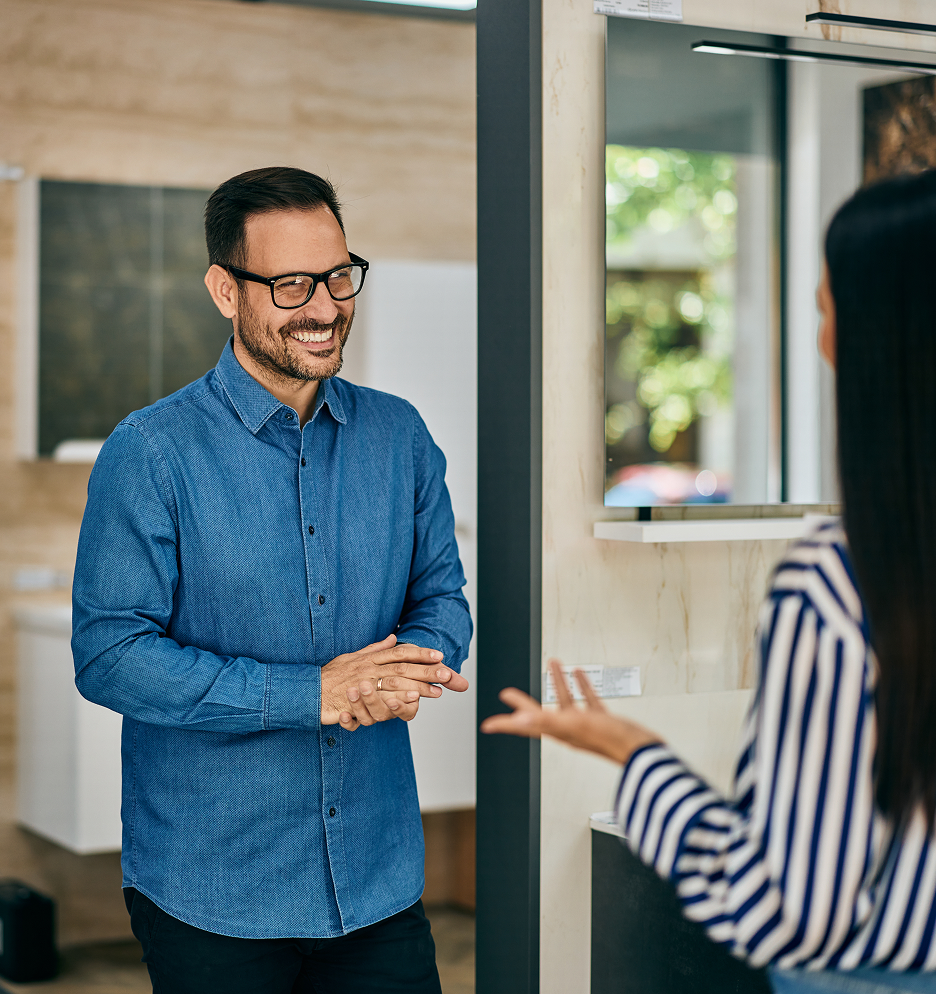 Man in a blue shirt smiling while speaking with a woman